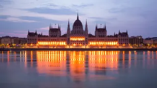 Clădirea Parlamentului Ungariei iluminată, văzută de pe malul Buda al Dunării