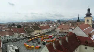Piața Mare din Sibiu văzută de sus, cu acoperișurile orașului și Carpații în depărtare