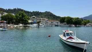 Port mic cu bărci și deal împădurit în Thassos